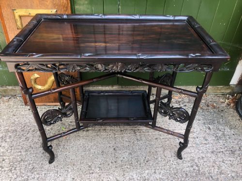 fig 1. A late Qing dynasty dark carved hardwood tray table featuring faux-bamboo legs, carved foliage aprons, and a lower tier shelf.