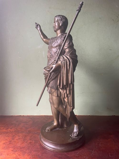 fig 1. A late nineteenth-century dark bronze sculpture depicting Emperor Augustus of Prima Porta standing in classical armor with his right arm raised.