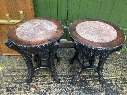 fig 1. A pair of circular late nineteenth-century Chinese hardwood stands featuring inset pinkish rouge marble tops and intricately carved aprons and legs.