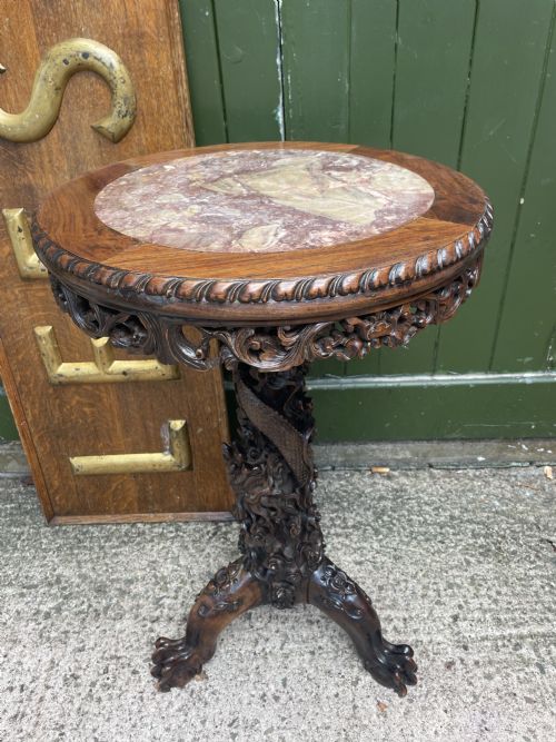 fig 1. A late nineteenth-century Chinese dark hardwood occasional table featuring a round inset marble top, intricately carved dragon column, and a tripod base.