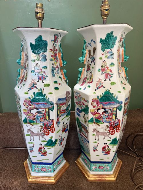 fig 1. A pair of hexagonal Chinese famille-verte porcelain lamps decorated with figures in traditional scenes and set on gilded bases.
