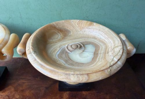 fig 4. A pair of 19th-century carved amber alabaster tazze with gadrooned rims and twin loop handles set on square black marble plinths.