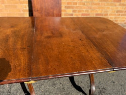 fig 3. An early 19th-century George III twin-pillar mahogany dining table featuring reeded splayed legs and original brass castors.