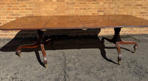 fig 6. An early 19th-century George III twin-pillar mahogany dining table featuring reeded splayed legs and original brass castors.
