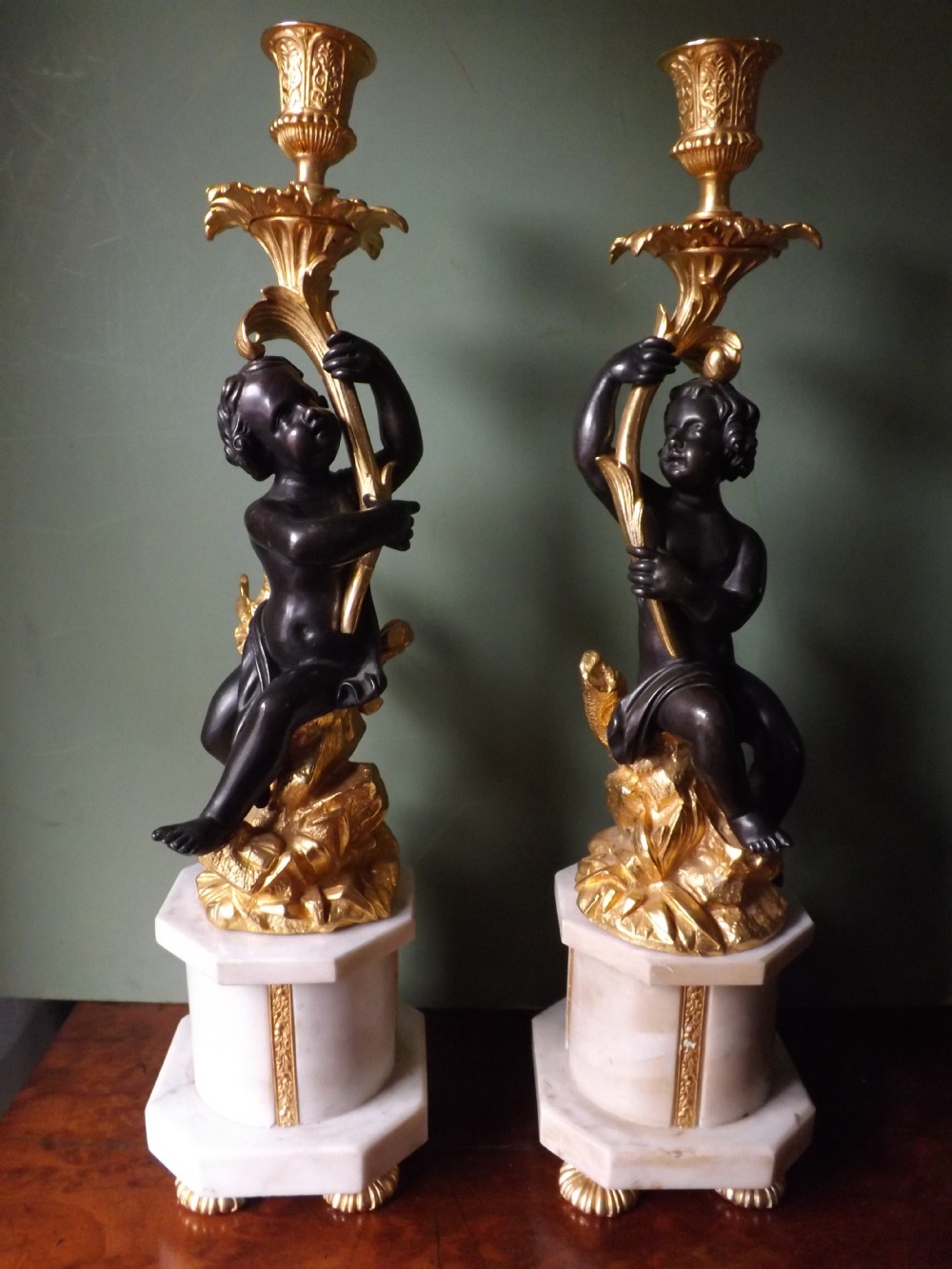 Pair of late C19th French bronze and ormolu candle-sticks on marble plinth bases.