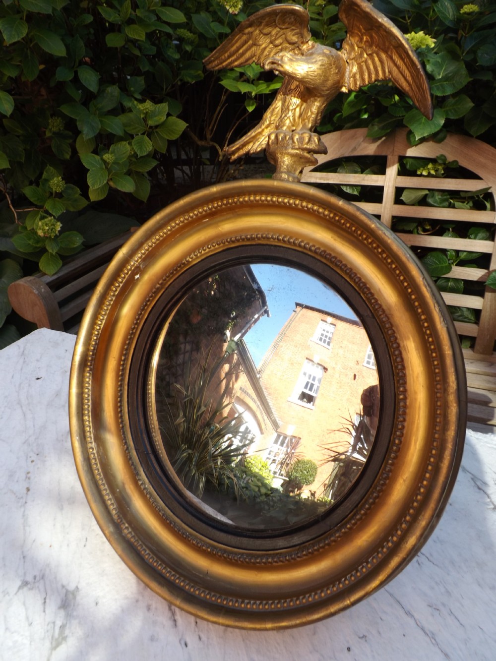Early C19th Regency period miniature gilt-wood convex-plate wall mirror.