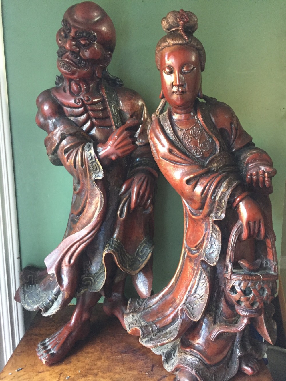 Pair of large C19th Japanese red lacquer decorated carved wooden figures .