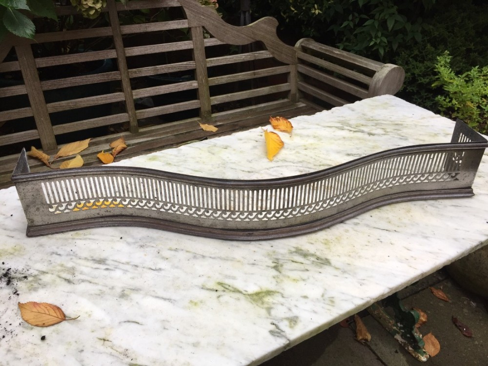 Small late C18th George III period cut and polished steel fire-place fender of serpentine outline.