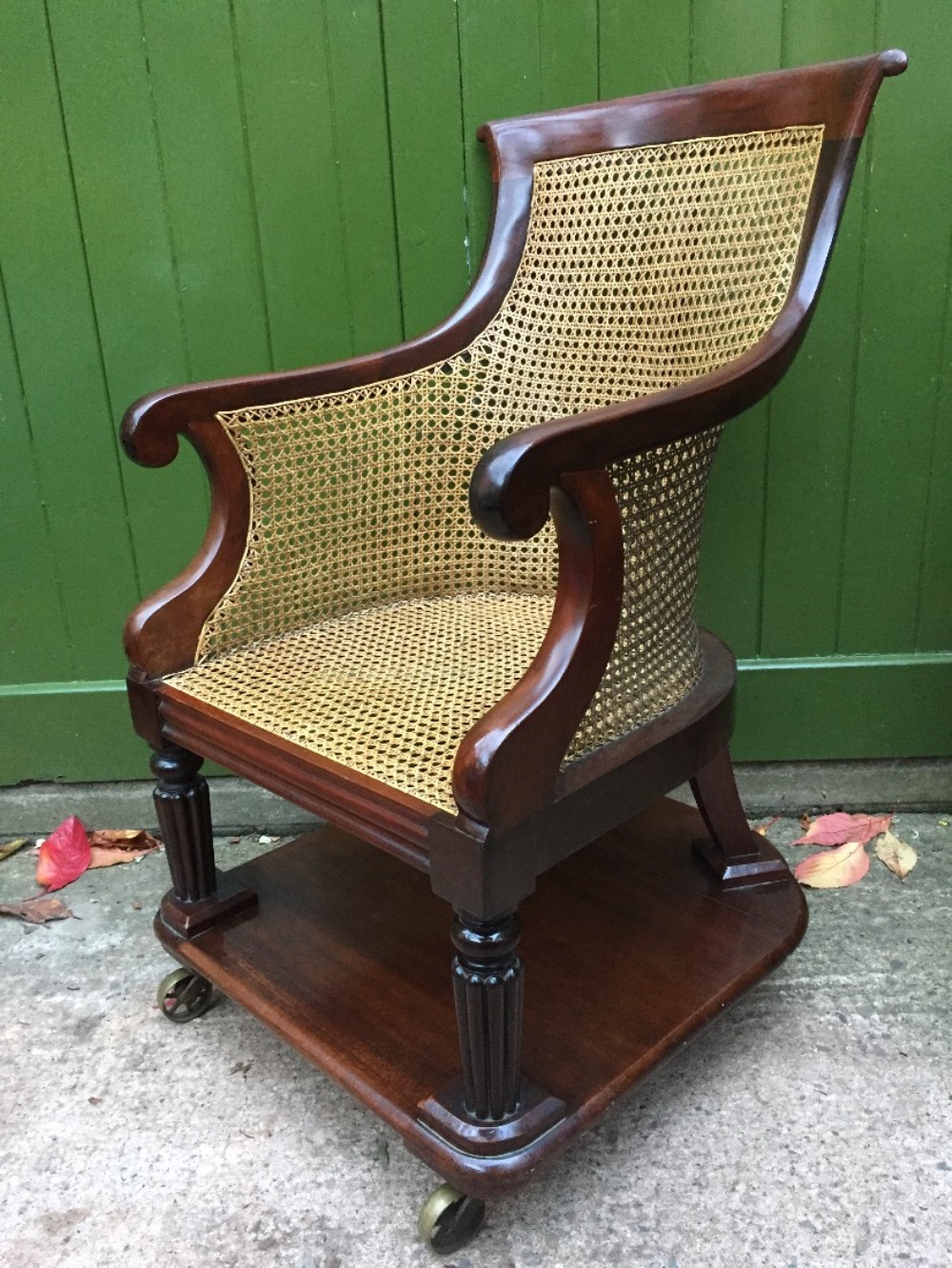 Early C19th George IV period mahogany framed gentlemans bergere library or desk armchair of rare form .