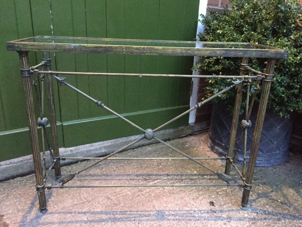 Early C20th brass-framed glass-topped console table of Empire design.