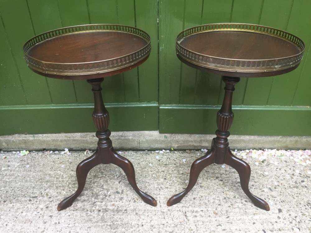 Pair of early C20th Georgian style mahogany tripod- base tables with pierced brass gallery-edge tops.