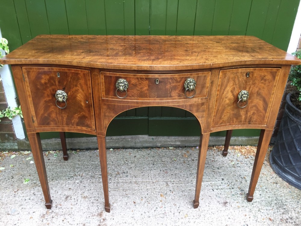 Late C18th George III period mahogany sideboard of serpentine outline and elegant compact proportions.