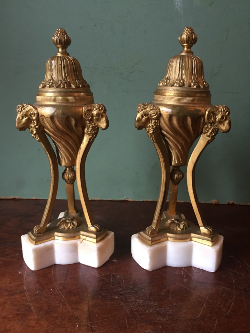 Pair of C19th gilt bronze cassolettes of neo-classical design on white marble bases.