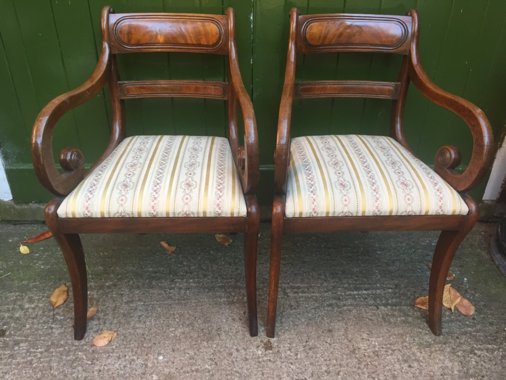 Pair of early C19th Regency period mahogany sabre-leg armchairs .