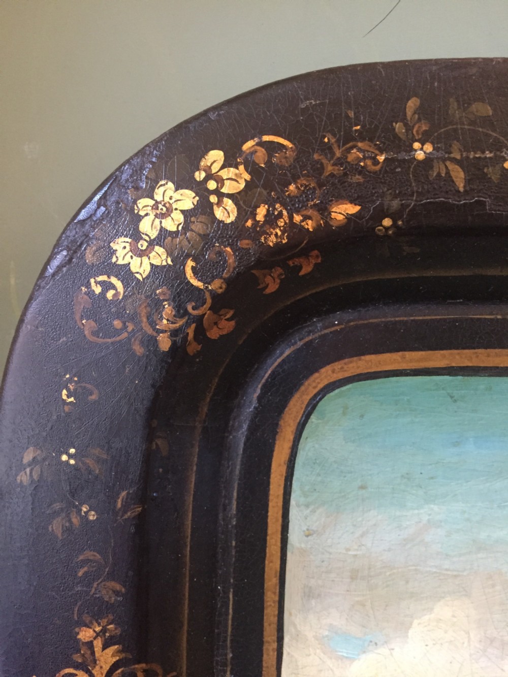 An early 19th-century rectangular papier-mache tray featuring a gilded scrollwork border and a central hand-painted scene of horsemen and hounds engaged in a fox hunt across a countryside landscape. View IX