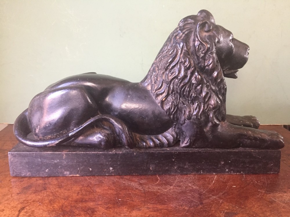 Late C19th cast-iron model of a recumbent lion on a rectangular plinth base. View IV