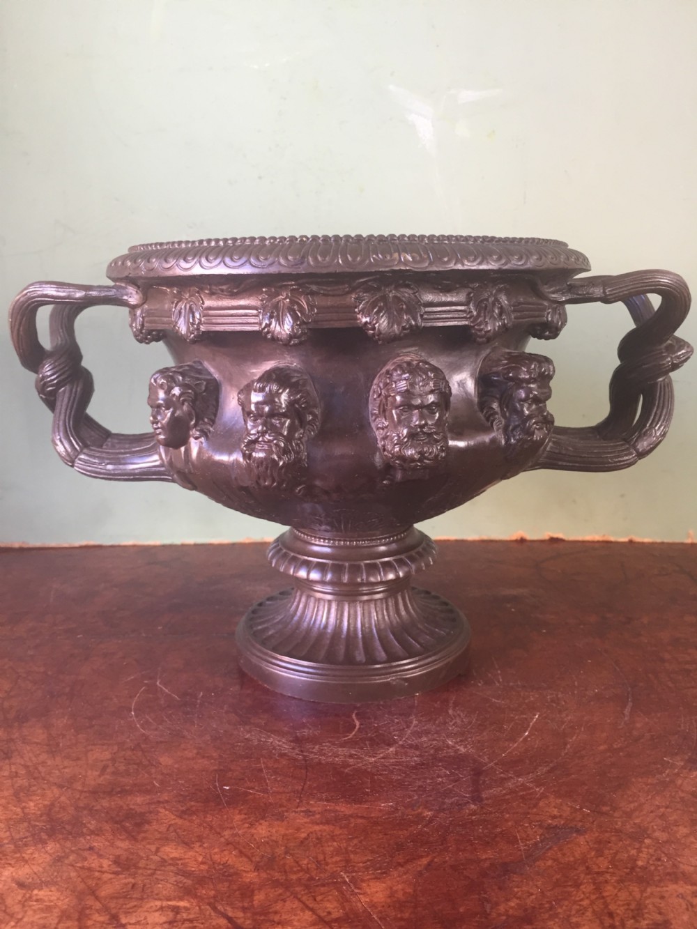 A nineteenth-century dark bronze reduction of the Albani Vase featuring classical sculpted masks along the body, intertwined handles, and a pedestal base. View II