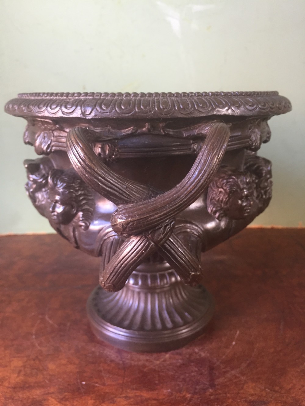 A nineteenth-century dark bronze reduction of the Albani Vase featuring classical sculpted masks along the body, intertwined handles, and a pedestal base. View V
