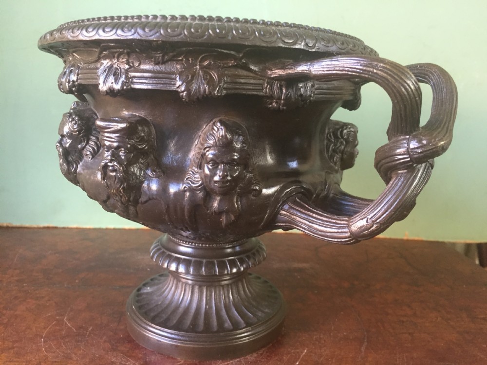 A nineteenth-century dark bronze reduction of the Albani Vase featuring classical sculpted masks along the body, intertwined handles, and a pedestal base. View VII