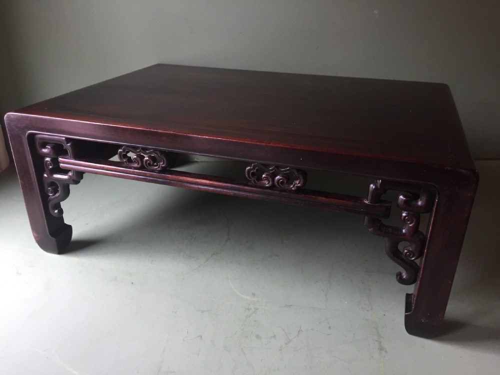 A late 19th-century Chinese dark hongmu hardwood scholars low table featuring carved cloud motif spandrels and straight legs. View II