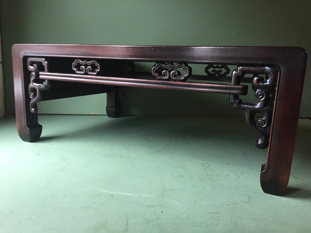 A late 19th-century Chinese dark hongmu hardwood scholars low table featuring carved cloud motif spandrels and straight legs. View VII