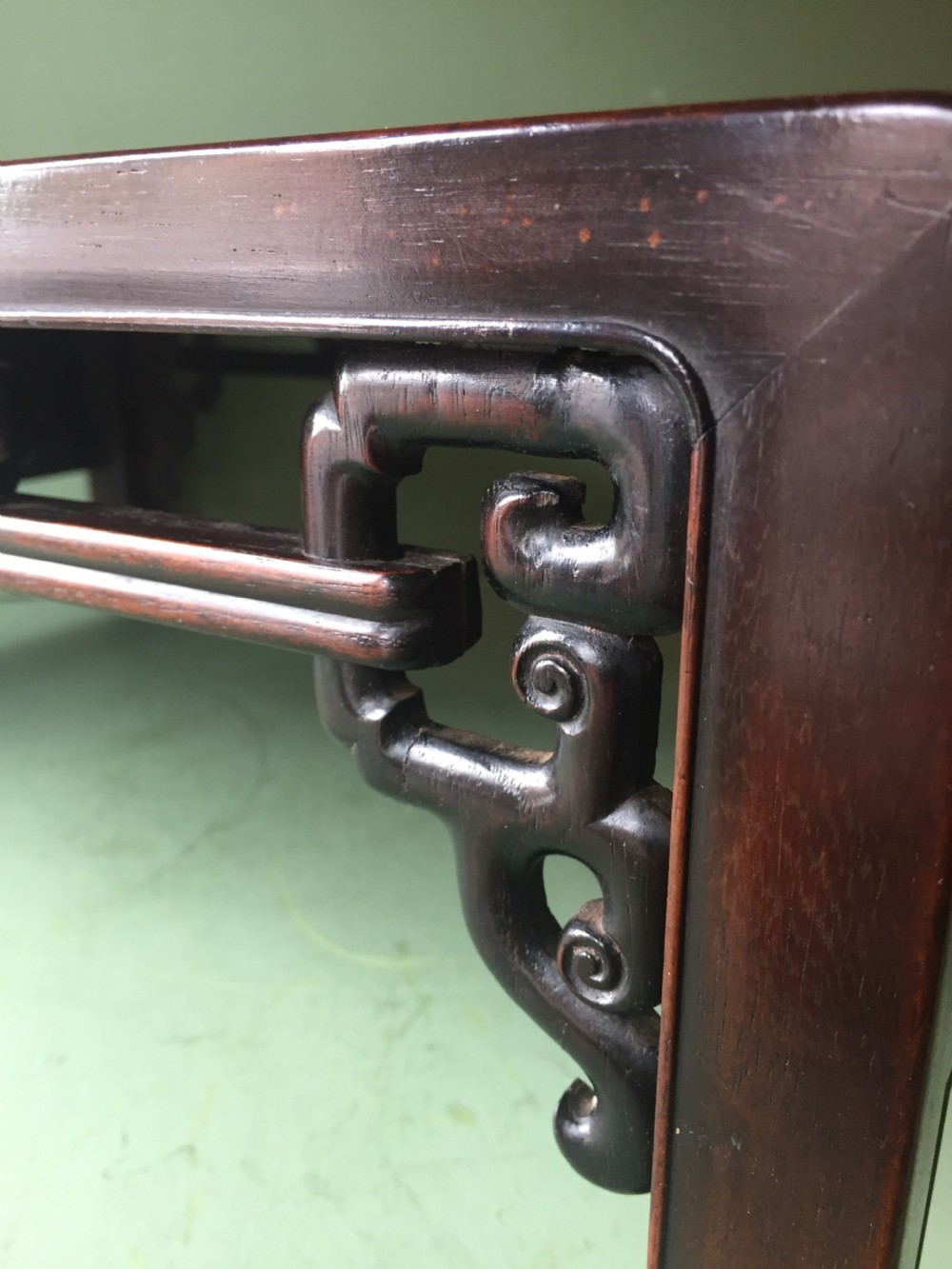 A late 19th-century Chinese dark hongmu hardwood scholars low table featuring carved cloud motif spandrels and straight legs. View XII