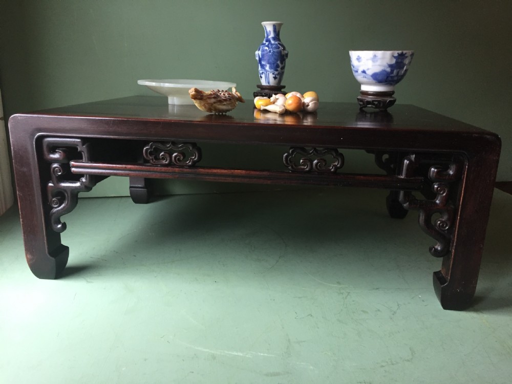 A late 19th-century Chinese dark hongmu hardwood scholars low table featuring carved cloud motif spandrels and straight legs. View XVIII