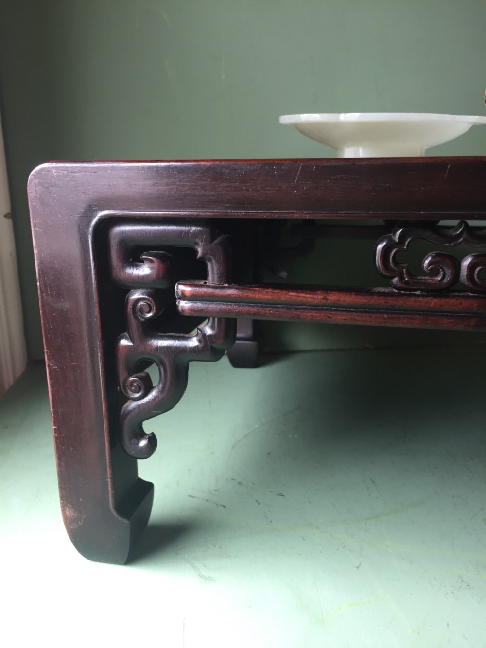 A late 19th-century Chinese dark hongmu hardwood scholars low table featuring carved cloud motif spandrels and straight legs. View XX