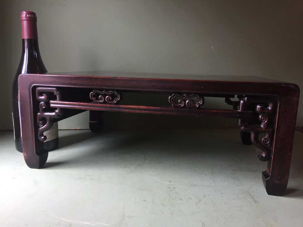 A late 19th-century Chinese dark hongmu hardwood scholars low table featuring carved cloud motif spandrels and straight legs. View XXII