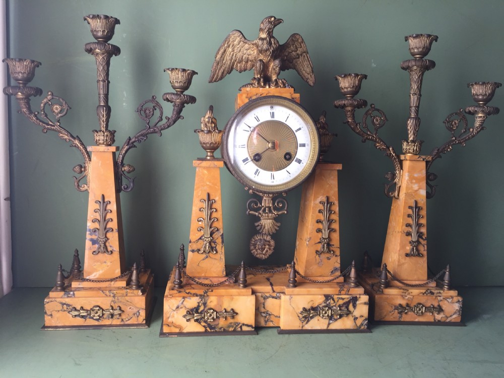 A late nineteenth-century French Empire style clock garniture crafted from yellow Siena marble and gilt ormolu, featuring a central clock topped with an eagle and flanked by two candelabra. View III
