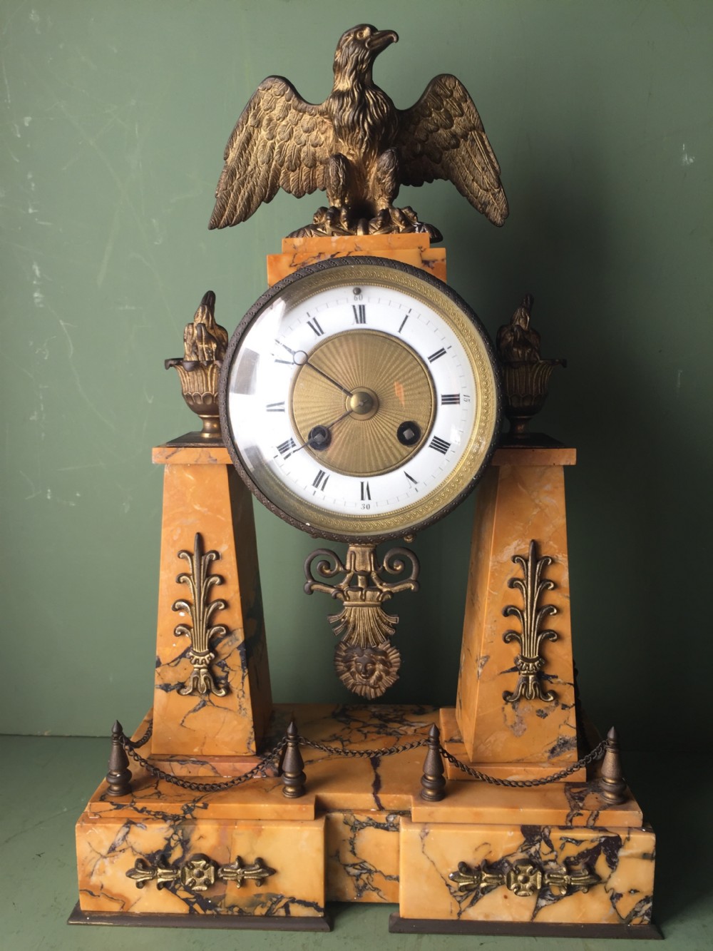 A late nineteenth-century French Empire style clock garniture crafted from yellow Siena marble and gilt ormolu, featuring a central clock topped with an eagle and flanked by two candelabra. View VII