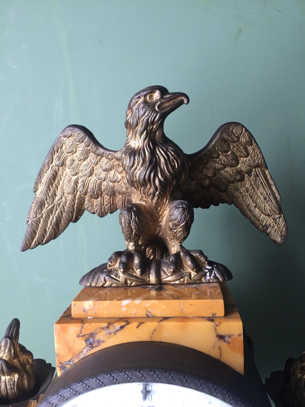A late nineteenth-century French Empire style clock garniture crafted from yellow Siena marble and gilt ormolu, featuring a central clock topped with an eagle and flanked by two candelabra. View VIII