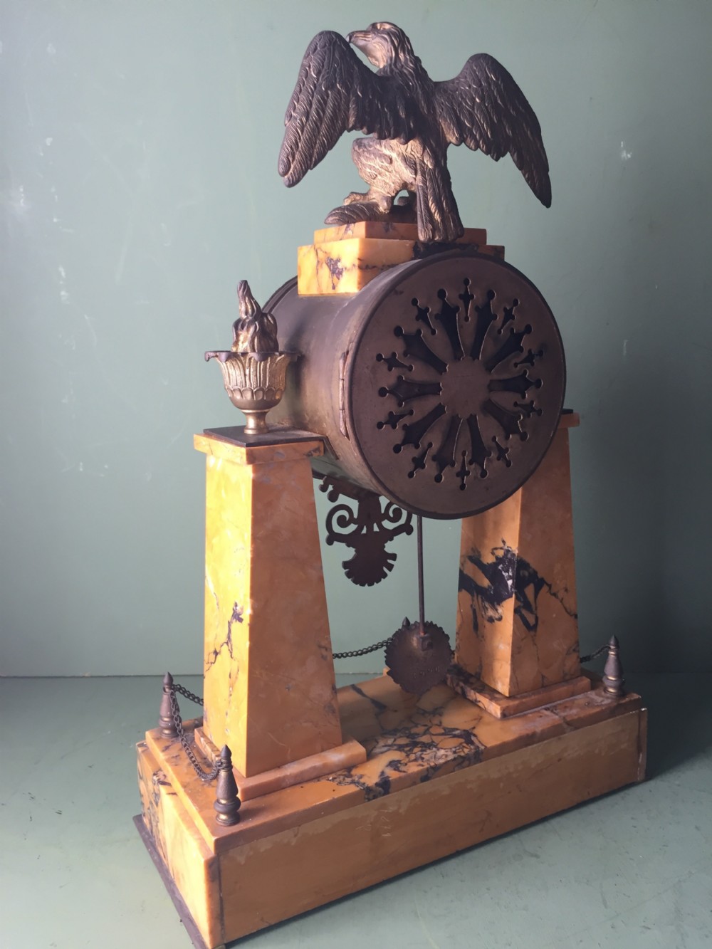 A late nineteenth-century French Empire style clock garniture crafted from yellow Siena marble and gilt ormolu, featuring a central clock topped with an eagle and flanked by two candelabra. View XII