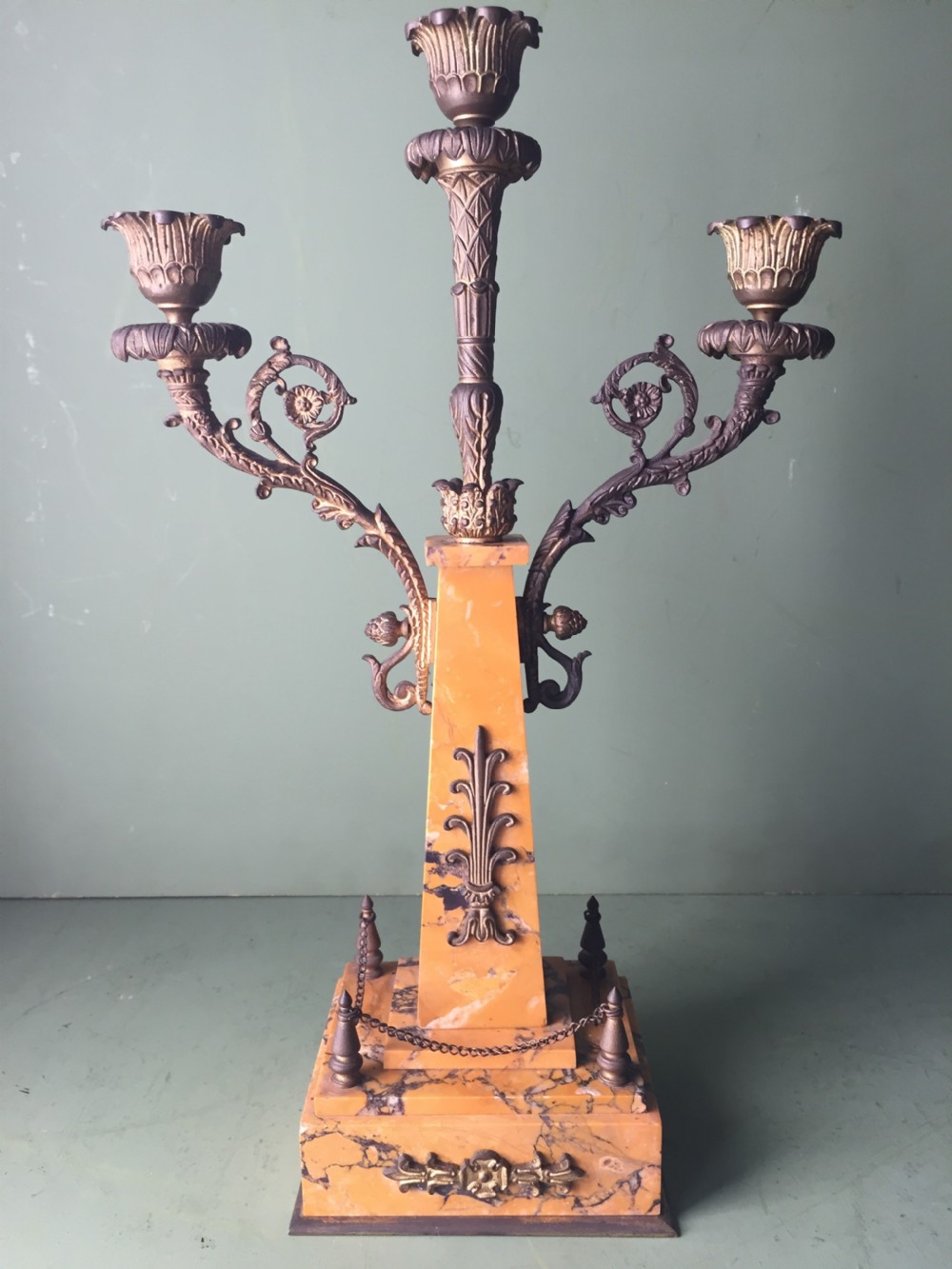 A late nineteenth-century French Empire style clock garniture crafted from yellow Siena marble and gilt ormolu, featuring a central clock topped with an eagle and flanked by two candelabra. View XX