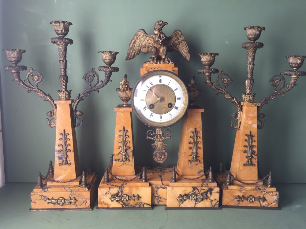 A late nineteenth-century French Empire style clock garniture crafted from yellow Siena marble and gilt ormolu, featuring a central clock topped with an eagle and flanked by two candelabra. View XXIII