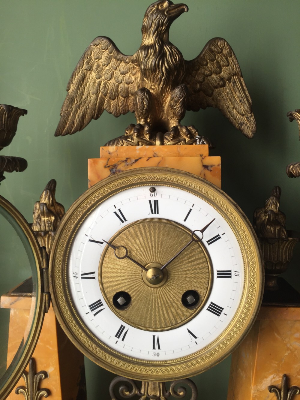 A late nineteenth-century French Empire style clock garniture crafted from yellow Siena marble and gilt ormolu, featuring a central clock topped with an eagle and flanked by two candelabra. View XXIV