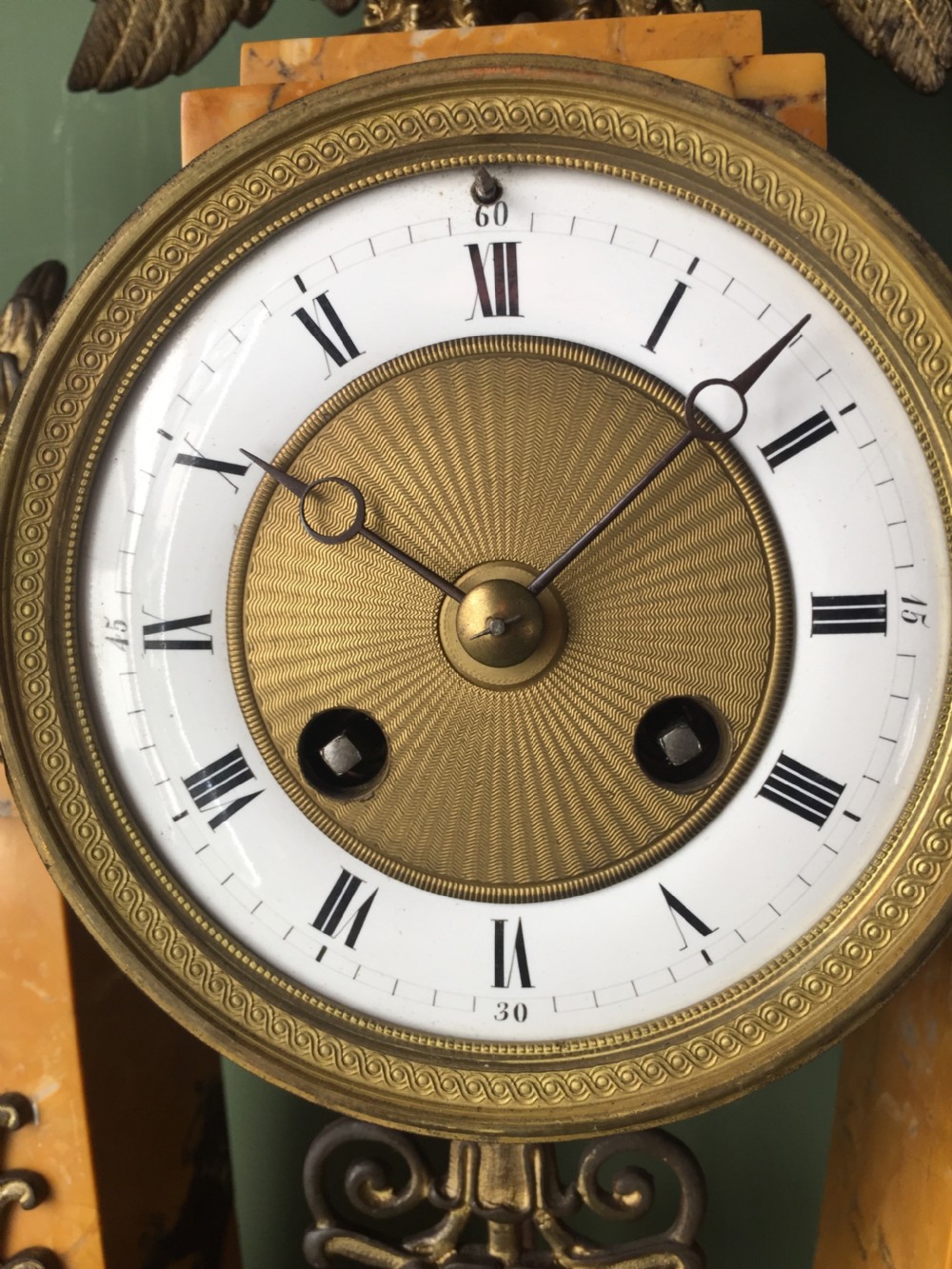 A late nineteenth-century French Empire style clock garniture crafted from yellow Siena marble and gilt ormolu, featuring a central clock topped with an eagle and flanked by two candelabra. View XXV