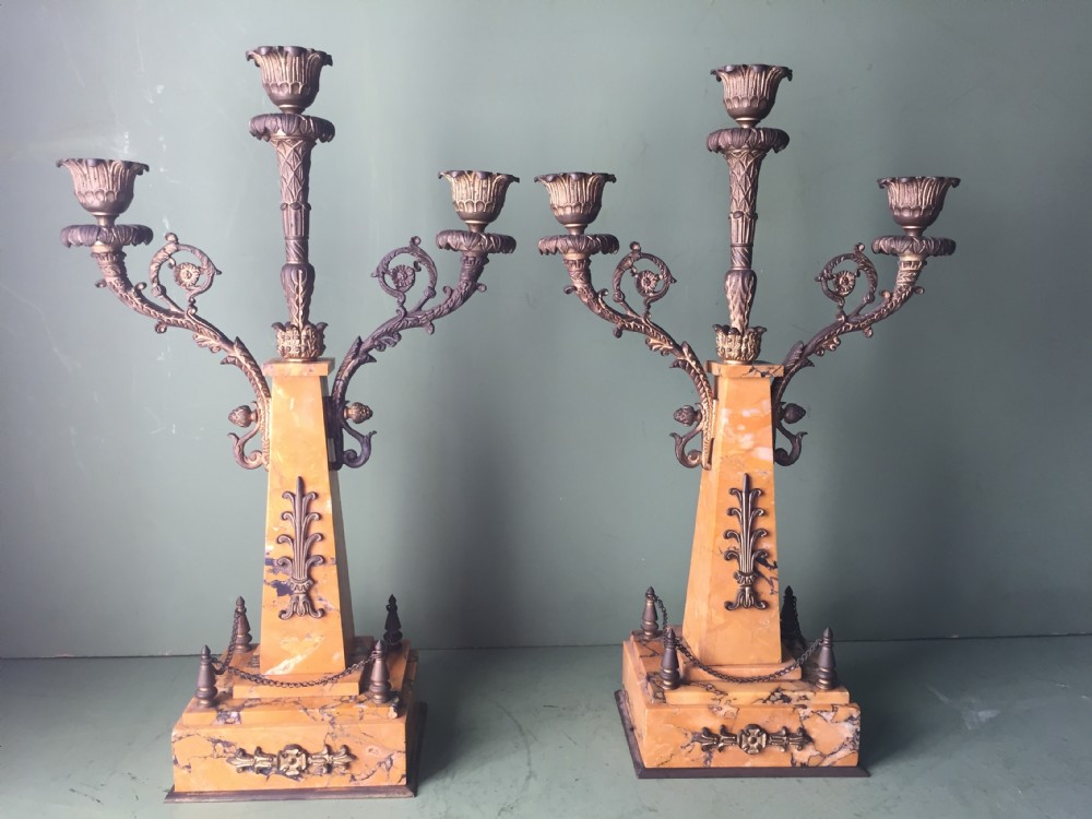 A late nineteenth-century French Empire style clock garniture crafted from yellow Siena marble and gilt ormolu, featuring a central clock topped with an eagle and flanked by two candelabra. View XXXII