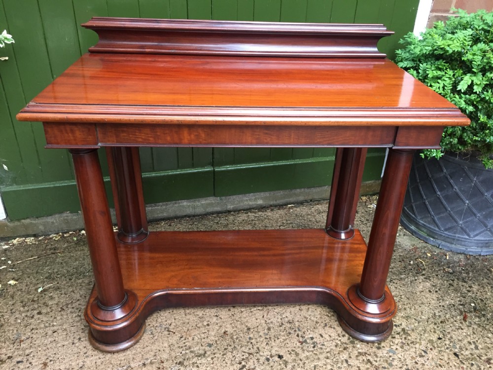 A William IV mahogany hall console table with cylindrical column supports, a raised rear gallery, and a lower plinth shelf. View III