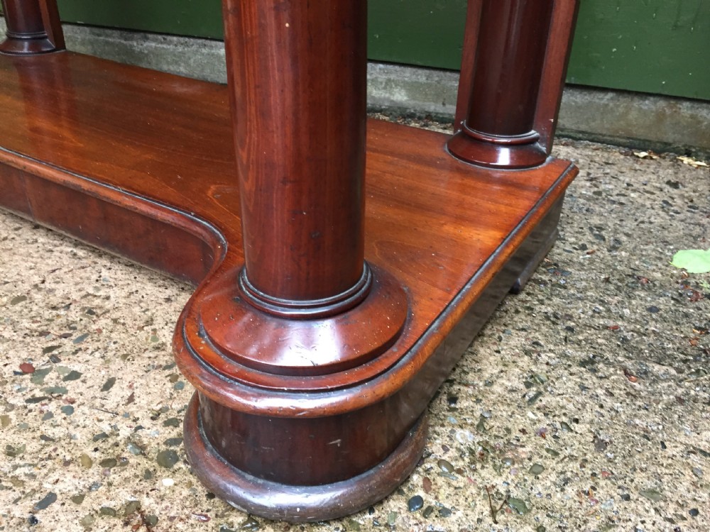 A William IV mahogany hall console table with cylindrical column supports, a raised rear gallery, and a lower plinth shelf. View IX