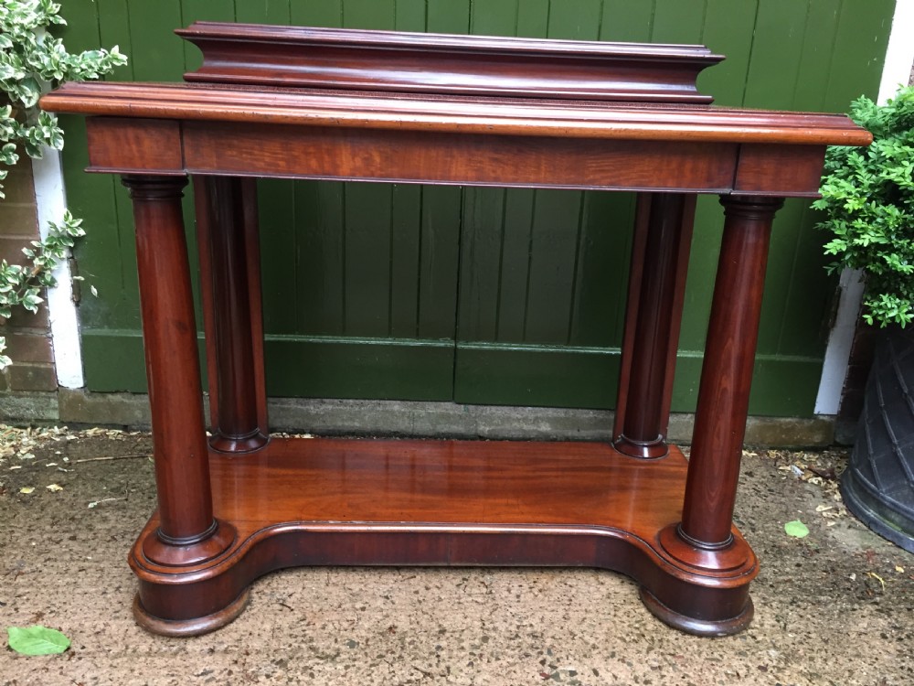 A William IV mahogany hall console table with cylindrical column supports, a raised rear gallery, and a lower plinth shelf. View X