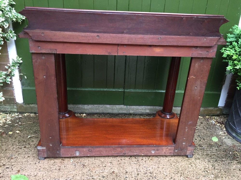 A William IV mahogany hall console table with cylindrical column supports, a raised rear gallery, and a lower plinth shelf. View XVI