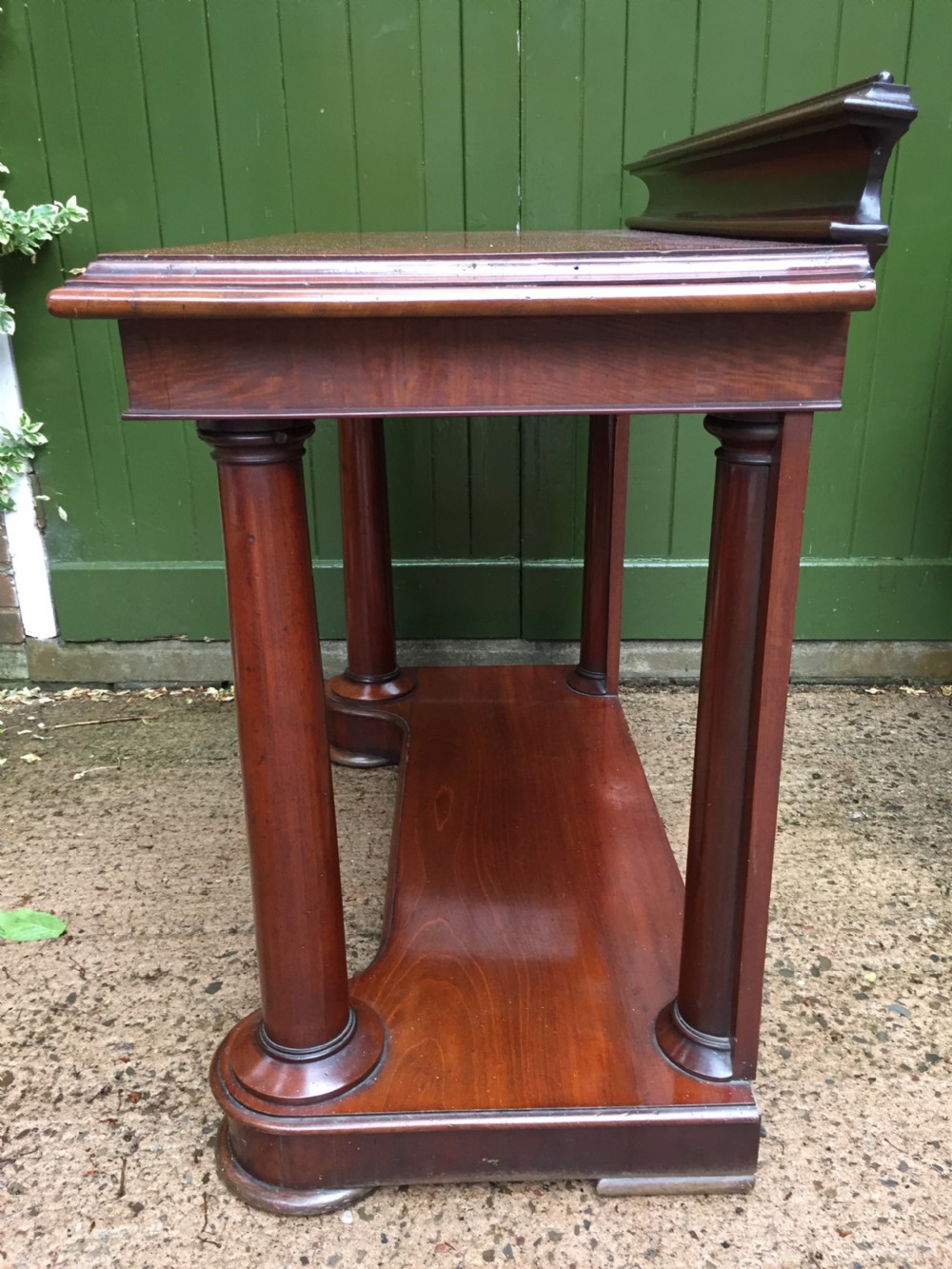 A William IV mahogany hall console table with cylindrical column supports, a raised rear gallery, and a lower plinth shelf. View XVII