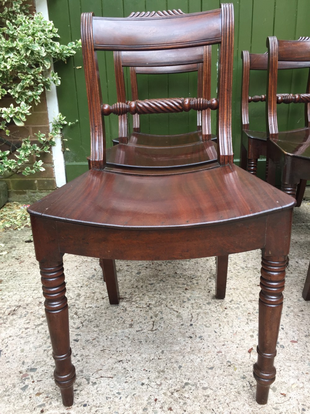 A set of six early nineteenth-century mahogany dining chairs featuring carved top rails, rope twist splats, solid wooden seats, and turned front legs. View VIII
