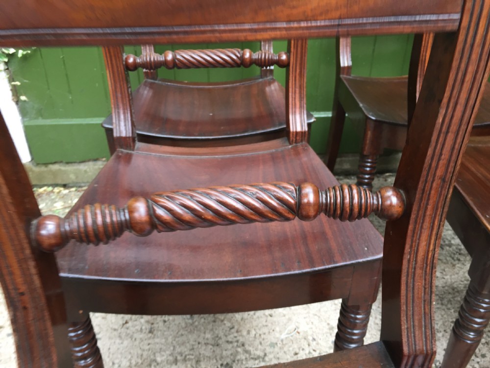 A set of six early nineteenth-century mahogany dining chairs featuring carved top rails, rope twist splats, solid wooden seats, and turned front legs. View IX