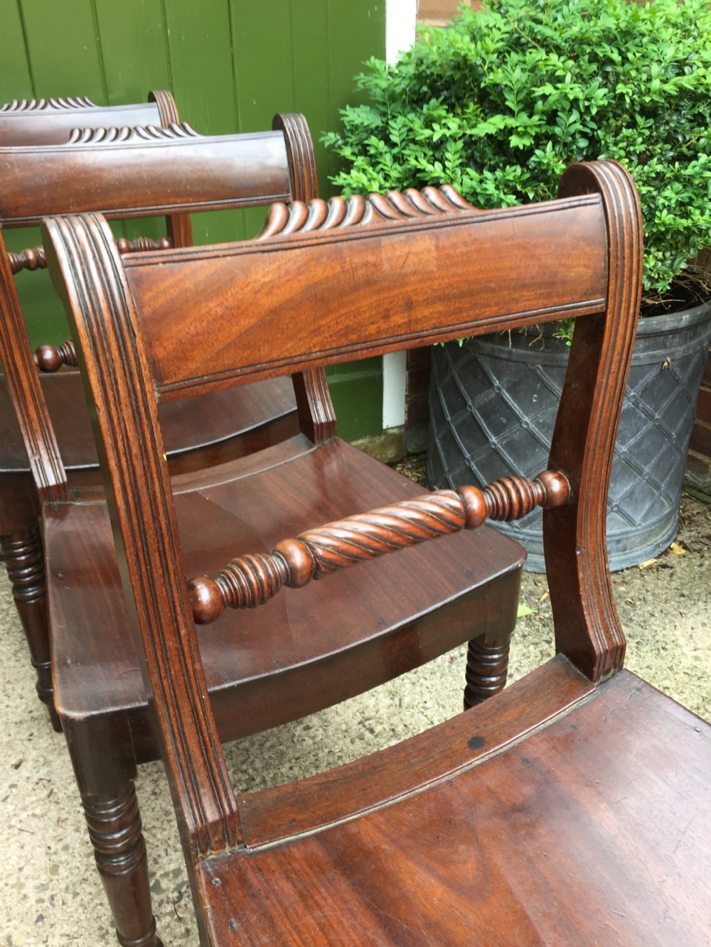 A set of six early nineteenth-century mahogany dining chairs featuring carved top rails, rope twist splats, solid wooden seats, and turned front legs. View XI