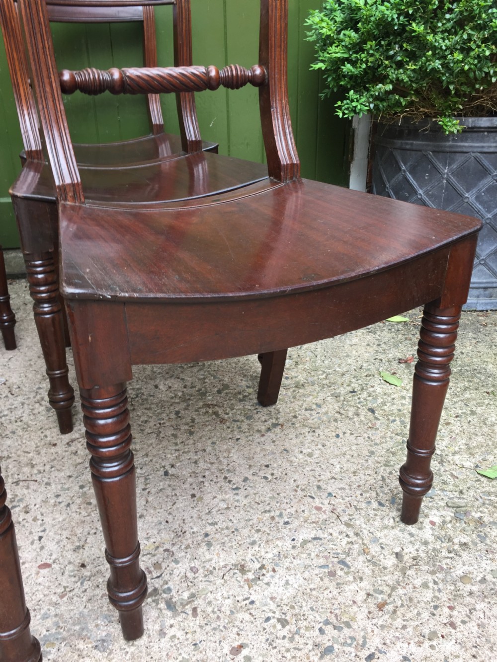 A set of six early nineteenth-century mahogany dining chairs featuring carved top rails, rope twist splats, solid wooden seats, and turned front legs. View XV