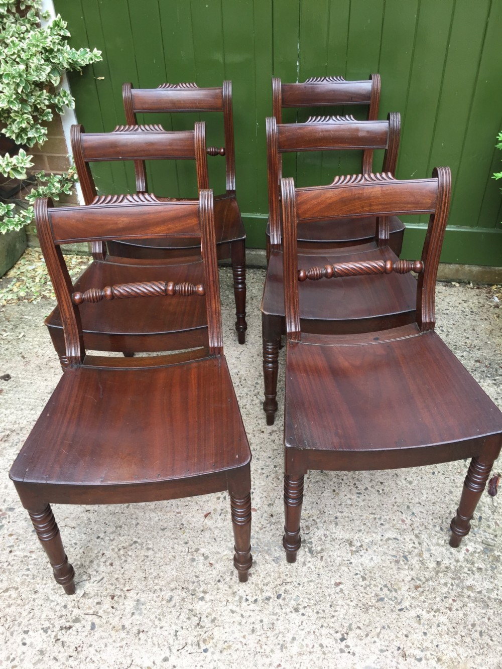 A set of six early nineteenth-century mahogany dining chairs featuring carved top rails, rope twist splats, solid wooden seats, and turned front legs. View XVI