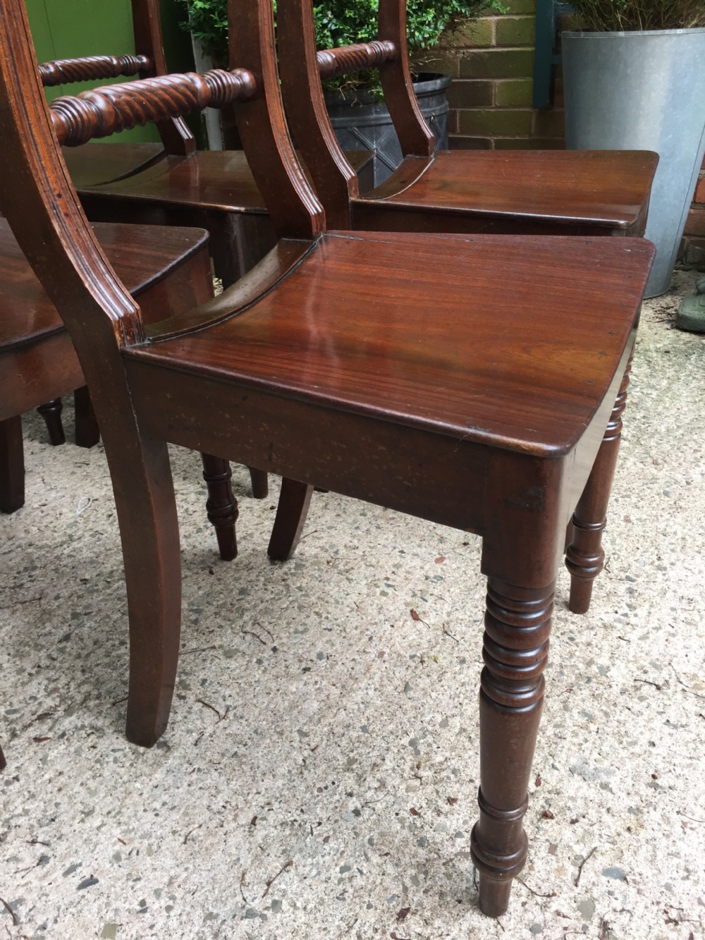 A set of six early nineteenth-century mahogany dining chairs featuring carved top rails, rope twist splats, solid wooden seats, and turned front legs. View XIX