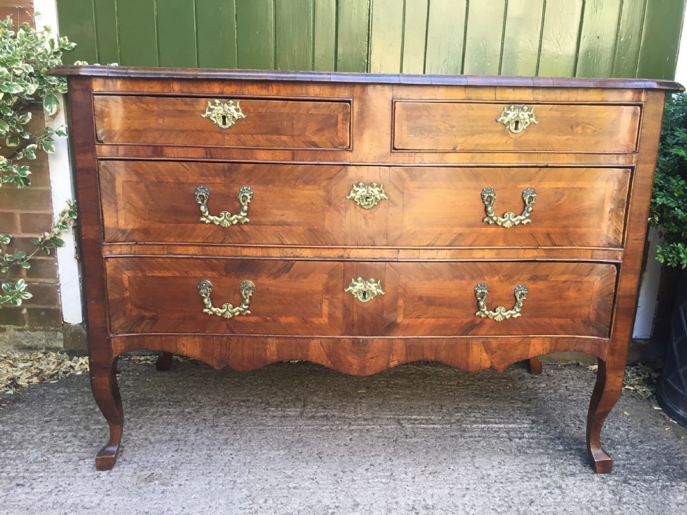 A mid-18th-century Italian serpentine commode with parquetry olive wood and walnut veneers and ornate brass mounts. View II